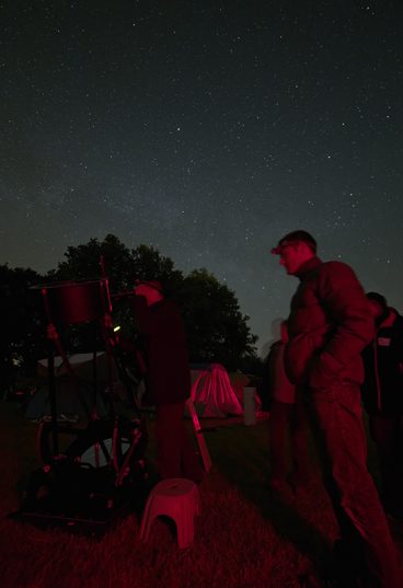 Observateurs en groupe autour d'un télescope Dobson
