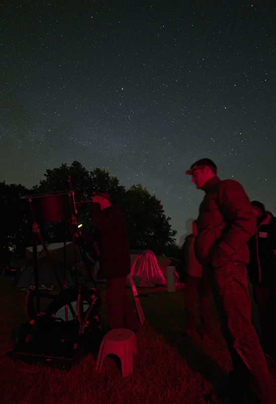 Observateurs en groupe autour d'un télescope Dobson