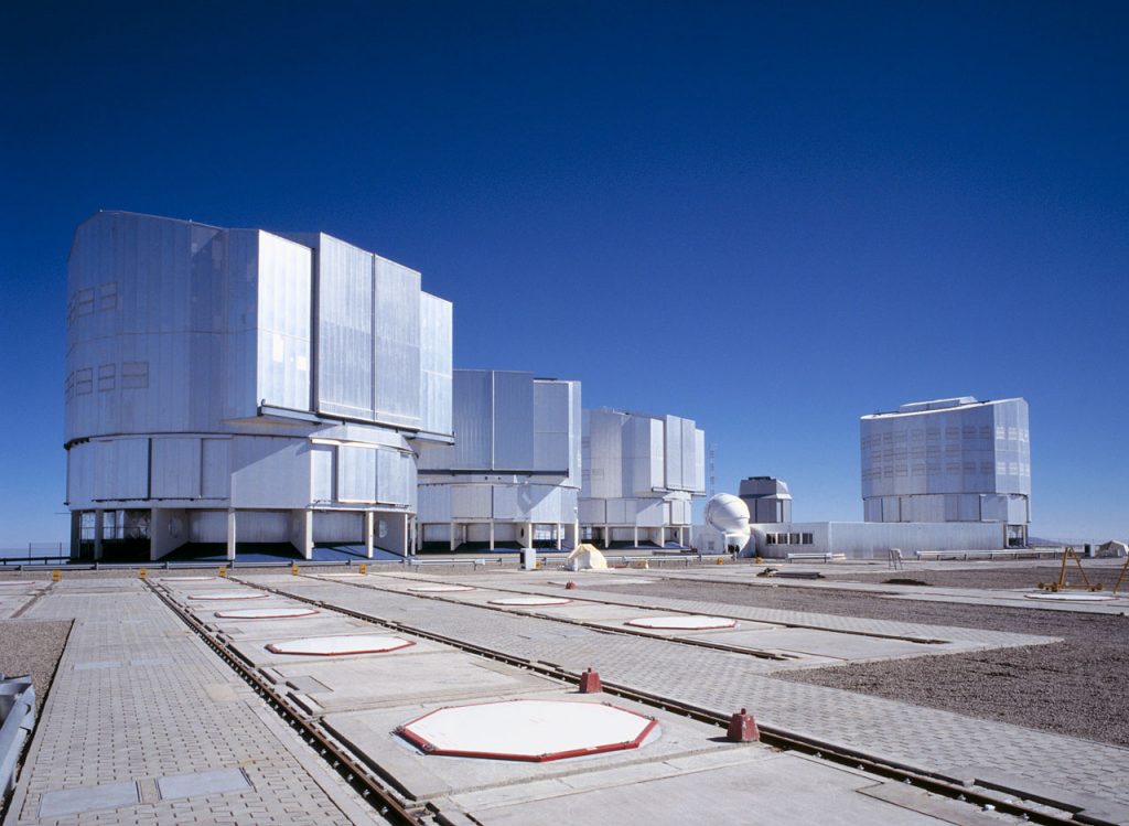 Photo montrant les six dômes composant le VLT, de gauche à droite: ANTU, KUEYEN et MELIPAL, les trois premiers télescopes principaux, un des quatre télescopes auxiliaire AT1, le VLT Survey Telescope et le dernier des quatre télescopes principaux YEPUN. 