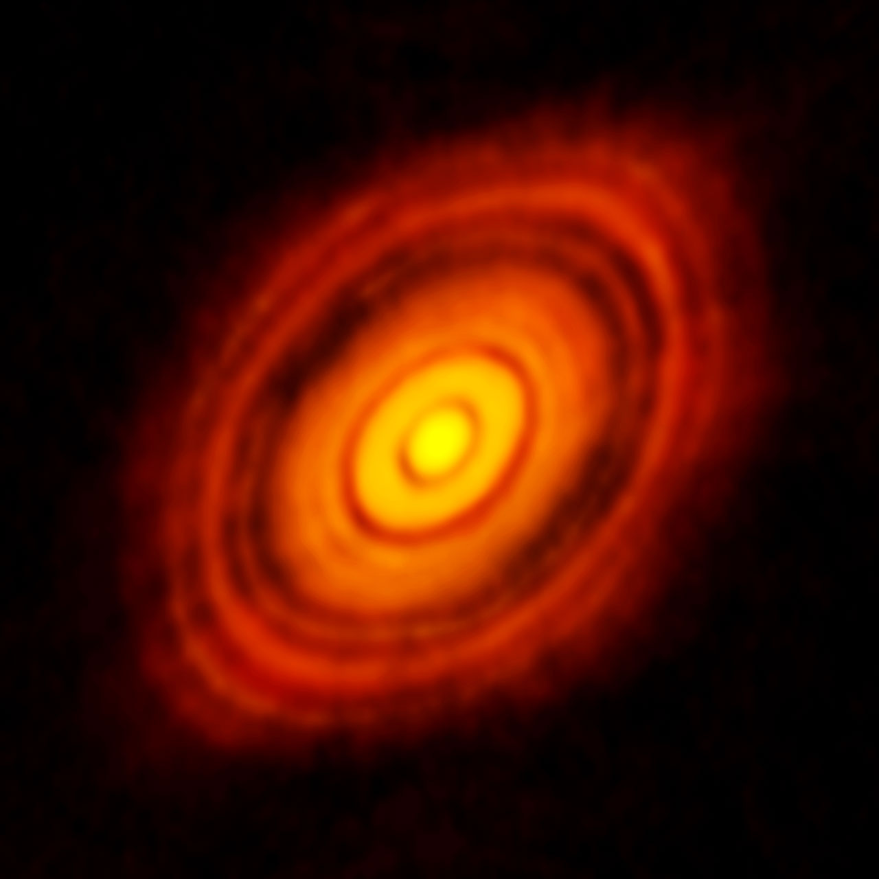 Première observation d'un disque protoplanétaire obtenue par ALMA en 2014, ici autour de la jeune étoile HL Tauri au centre de l'image. Des cercles sombres correspondent aux orbites des futures planètes, et alternent avec des cercles brillants de gaz..