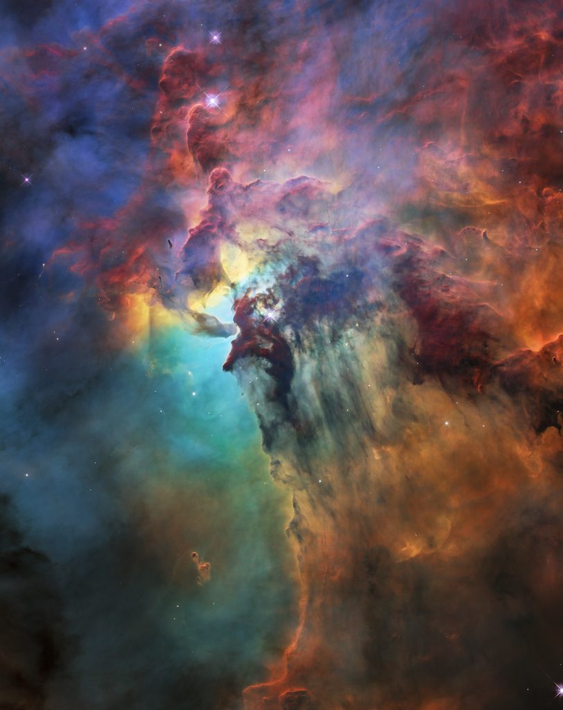 Impressionante image de la nébuleuse du Lagon prise par Hubble pour son 28e anniversaire. Couleurs : turquoise, rouge et noir.