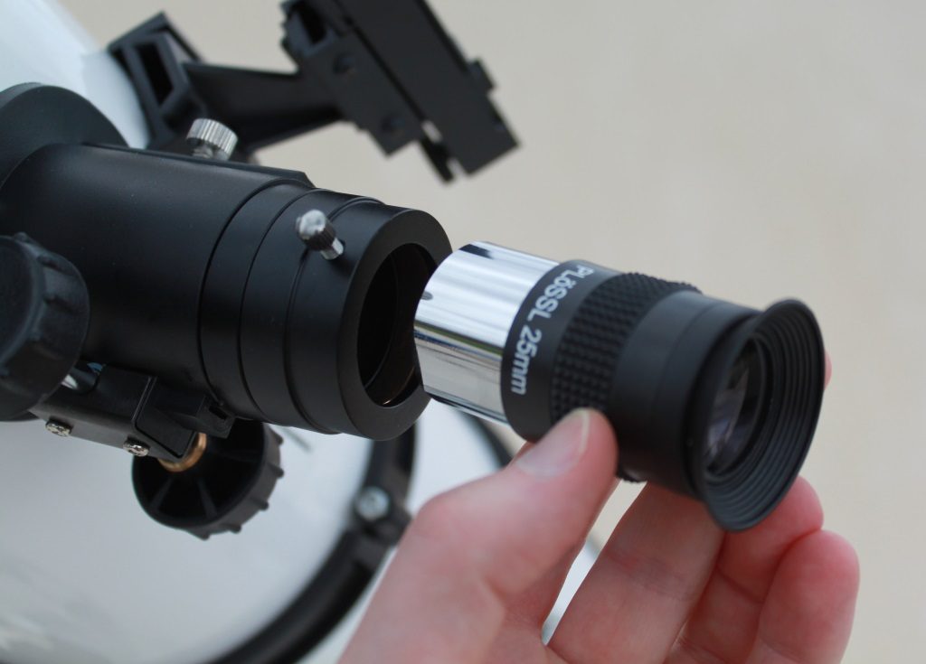 Photo montrant la mise en place d'un oculaire sur un télescope.