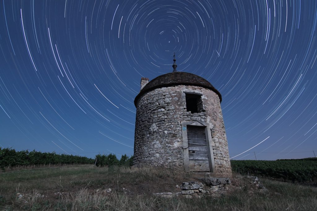 Photo montrant le mouvement apparent du ciel dû à la rotation de la Terre. Les étoiles semblent tourner autour de l'étoile Polaire au fil des heures.