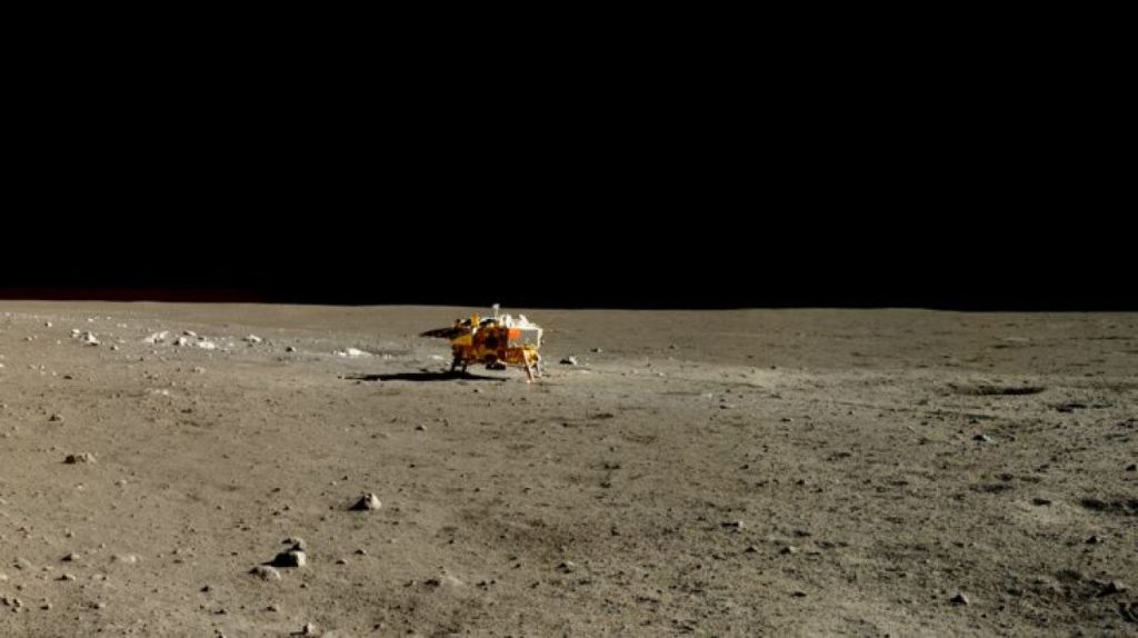 Photo réelle de l'atterrisseur Chang'e 3 prise par le rover Yutu. On le voit petit, perdu dans l'immensité lunaire.