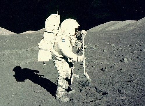 Photo de Harrison Schmitt en combinaison spatiale, au Soleil, qui ramasse des échantillons lunaires en 1972 (mission Apollo 17).