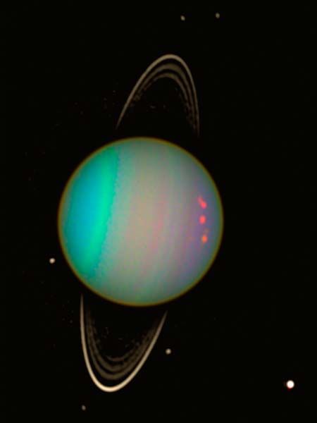 Uranus vue par Hubble : on voit la planète en couleurs bleu et violet, entourée de quelques-uns de ses satellites et de ses anneaux étroits représentés en blanc.