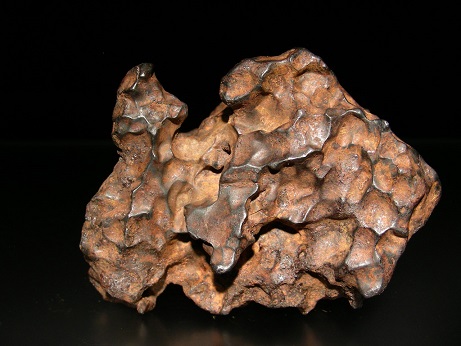 Météorite avec "empruntes de pouce", elle va du marron très foncé au marron clair au centre d'une multitude de creux dessinés dans la roche.