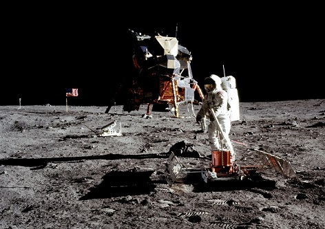 Photo de Buzz Aldrin en combinaison sur le sol lunaire le 20 juillet 1969 prise par Neil Armstrong. En fond, on voit à gauche le drapeau américain et à droite l'atterrisseur lunaire. 