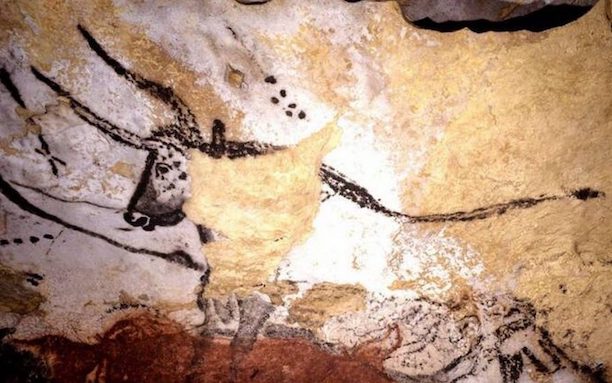 Peinture rupestre dans la grotte de Lascaux qui représente en marron foncé les contours d'un aurochs, bovin préhistorique. Le fond de la grotte est en pierre jaunie et au-dessus de l'animal on distingue six points marrons qui représenteraient les Pléiades. 