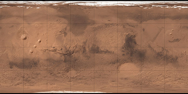 Surface de Mars reconstituée grâce à la sonde Mars Global Surveyor : on voit en vrai couleur rouge/orangé la surface de Mars avec des mers, des cratères et les zones sombres qui sont censées correspondre aux canaux artificiels. 