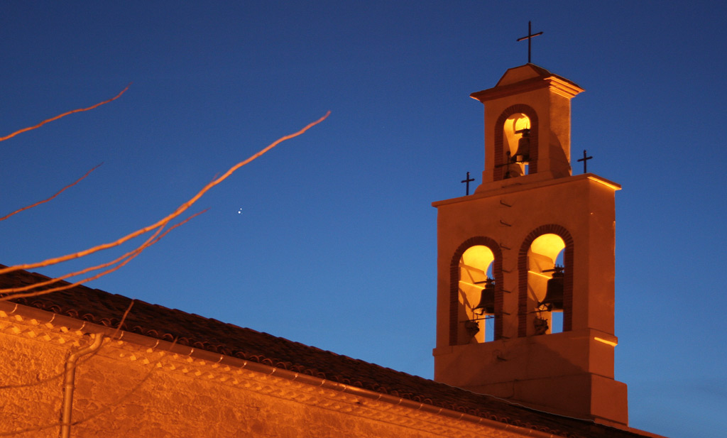 Clocher du sud-ouest sur fond de ciel crépusculaire, avec deux points lumineux qui représentent Saturne et Jupiter.