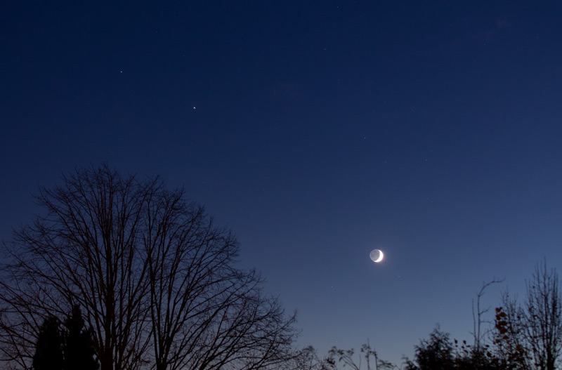 Photo montrant la Lune, Jupiter et Saturne dans le ciel crépusculaire le 18 novembre. La Lune est en croissant avec la lumière cendrée, Jupiter est un point plus brillant que Saturne.