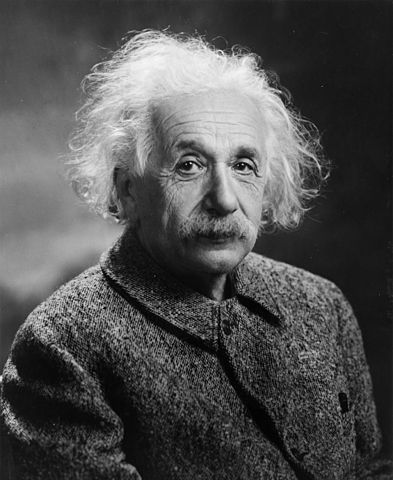 Photo en noir et blanc d'Einstein. On voit son buste et sa tête, il est habillé d'une veste épaisse fermée et a les cheveux blancs, ébouriffés. Il a une moustache. 