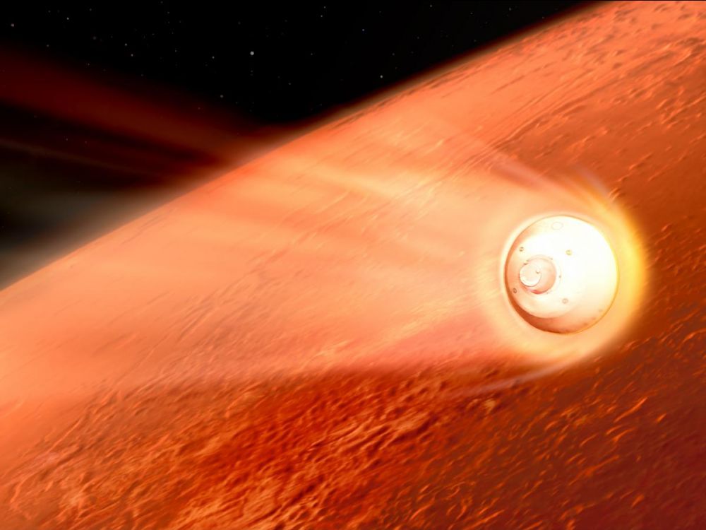 Capsule de la mission Mars 2020 en cours de rentrée dans l'atmosphère de Mars : sur toute l'image on voit la planète rouge, et au premier plan le vaisseau spatial en couleur blanc, avec une traînée comme une comète due aux frottements avec l'atmosphère. 