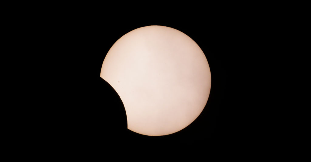 Eclipse partielle de Soleil : on voit le disque solaire avec une échancrure noire correspondant à l'endroit où se trouve la Lune.