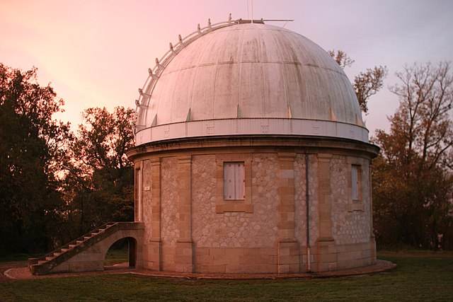 Coupole de l'Observatoire de Bordeaux, toit blanc et murs en pierres claires, en fin de journée donc avec une lumière dans les tons rose et violet.