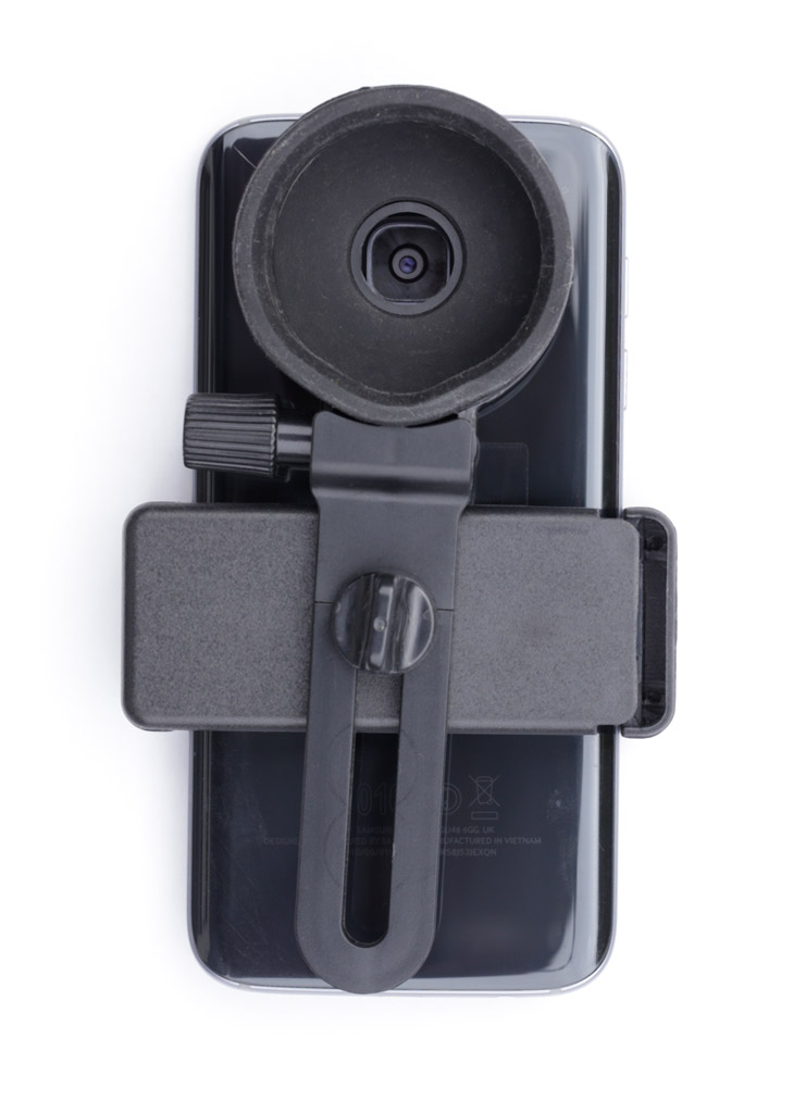Photo d'un smartphone fixé sur son adaptateur, avec son objectif centré dans la fenêtre de visée.