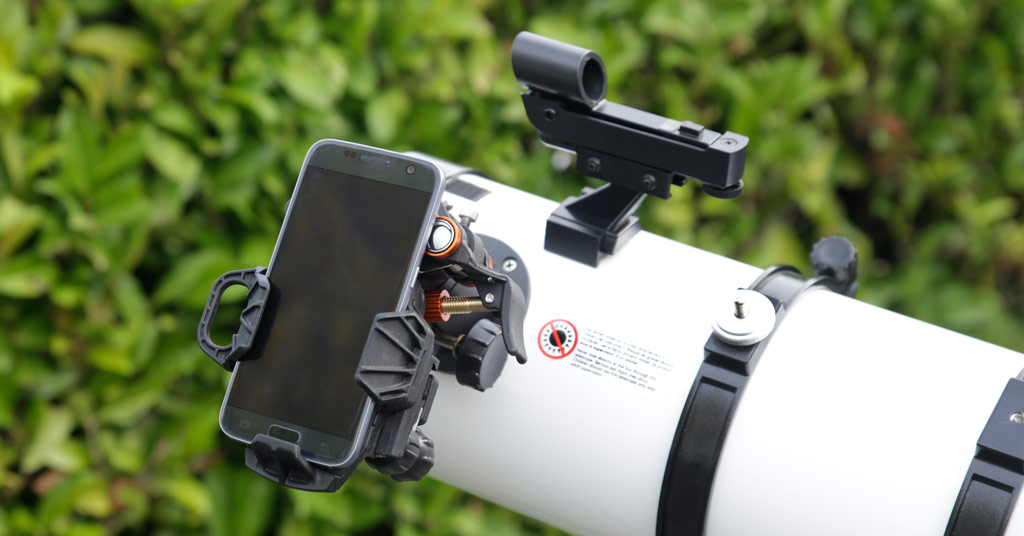 Photo montrant un smartphone fixé sur un télescope à l'aide d'un adaptateur spécifique.
