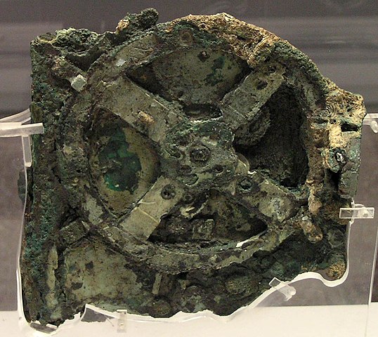 Roue en bronze verdâtre qui fait partie du mécanisme de la machine grecque d'Anticythère. Elle est recouverte d'algues par endroits car elle a été retrouvée dans une épave. 