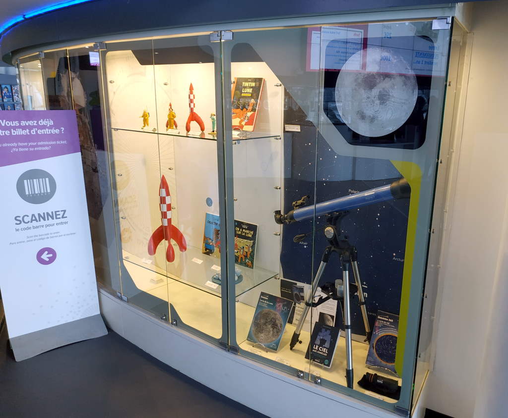 photo de la vitrine de la boutique de la Cité de l'espace avec les produits Stelvision mis en valeur aux côtés de la fusée de Tintin