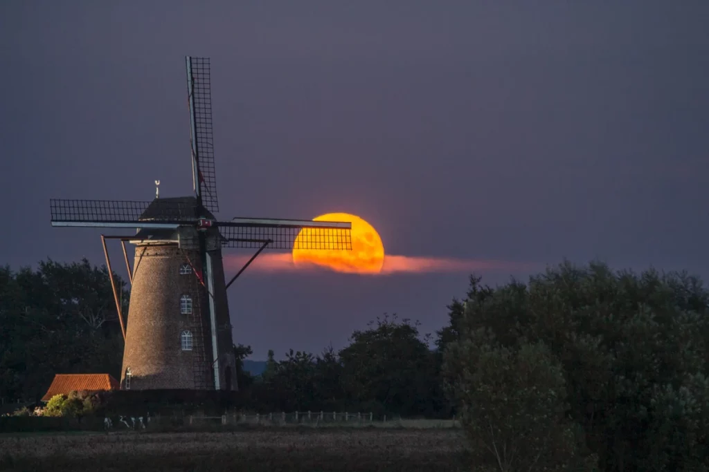 photo du lever de Lune derrière un moulin