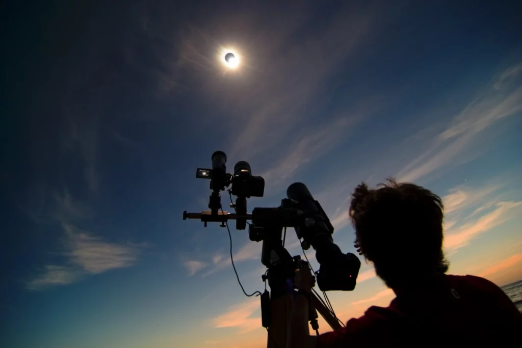 Photo d'un chasseur d'éclipses lors de l'éclipse du 29 mars 2006 en Turquie, avec tous ses appareils photo et téléobjectifs braqués sur le Soleil. Photo : U.Voltmer/Novapix, extraite du livre Les soleils noirs de 2026 et 2027 (Jean-Marc Lecleire, éd. Stelvision).
